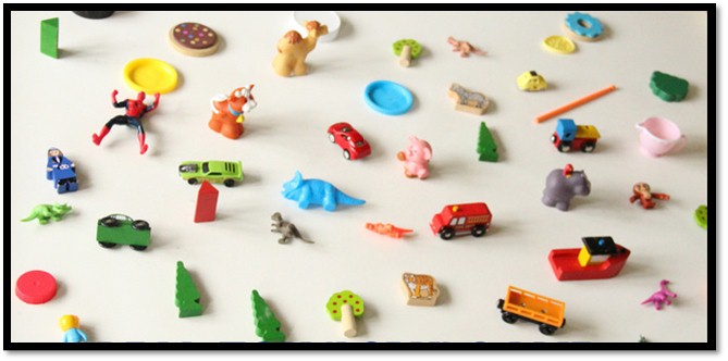 손바닥 크기의 초록색 공룡 소품 2개, 나무 소품 3개, 보트 소품 1개, 수레 소품 1개, 자동차 소품 4개, 쟁반 소품 2개, 코끼리 소품 1개, 코알라 소품 1개, 소 소품 1개, 낙타 소품 1개 등 35개의 소품이 바닥에 놓여있다.